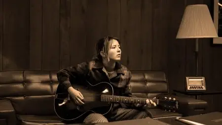 Woman with a guitar on a couch