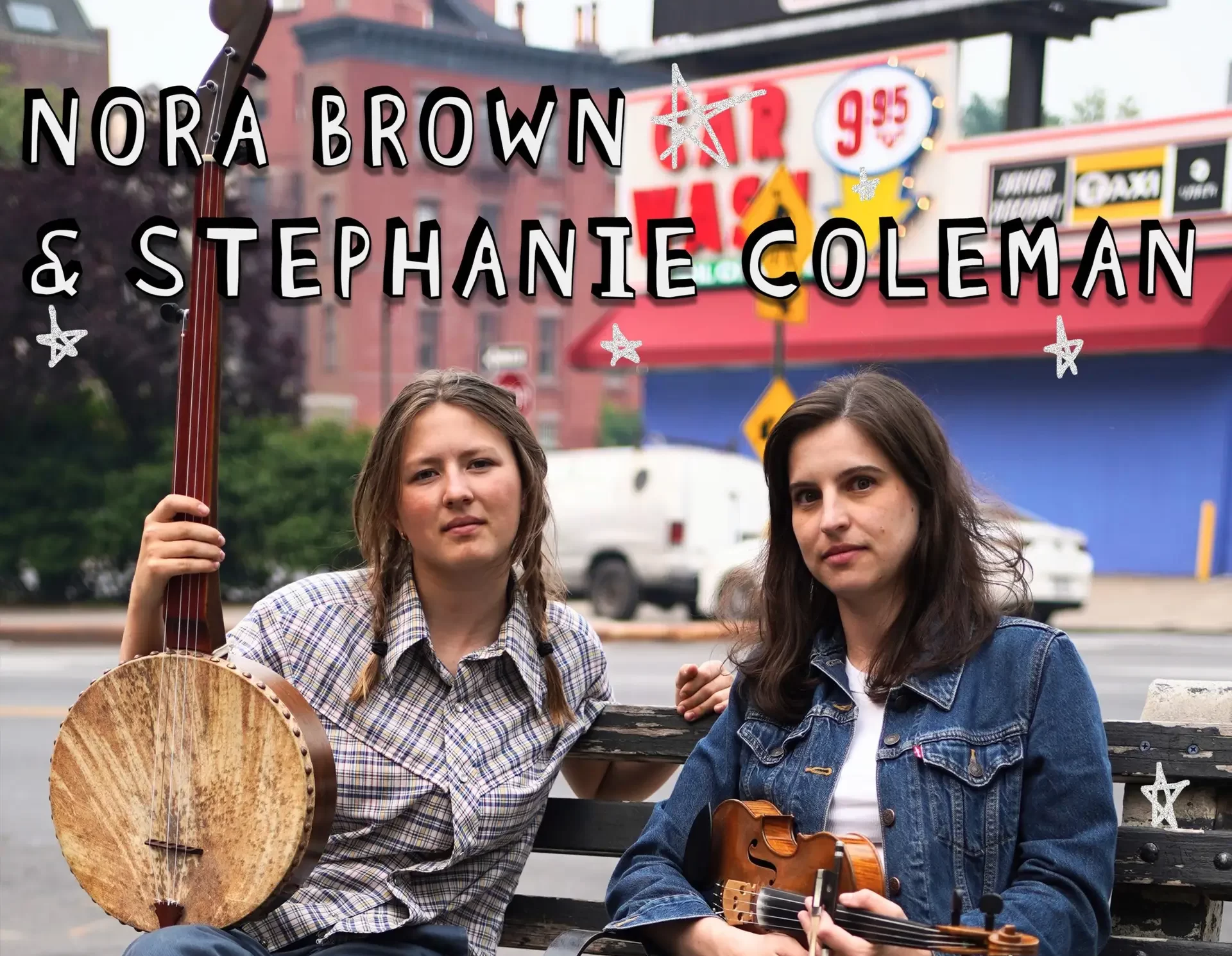 Two women with a banjo and a fiddle sitting on a bench